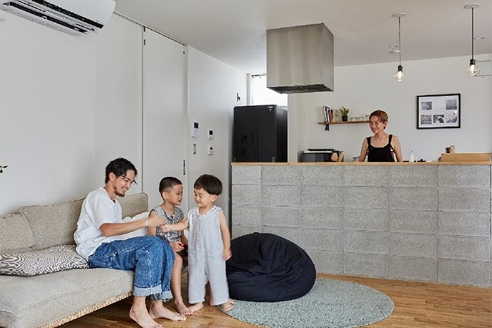 コンクリートブロックで壁を立ち上げて、あえて無機質な空間に仕上げたキッチン。家事をしているときも家族とのつながりを感じることができる。