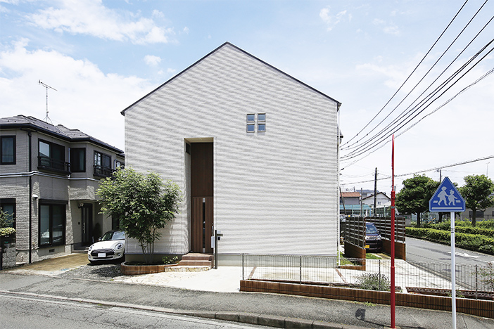 三角屋根のフォルムがかわいらしい外観デザイン。白を基調に凹凸部分は木目調でアクセント。